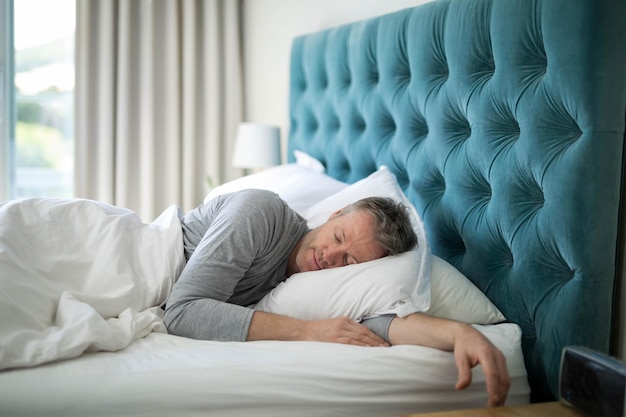 freepicdownloader.com mature man sleeping side master bedroom white pillow duvet copy space normal 1