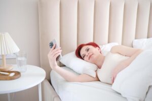 freepicdownloader.com young woman is relaxing bed with her smartphone enjoying comfort serenity normal